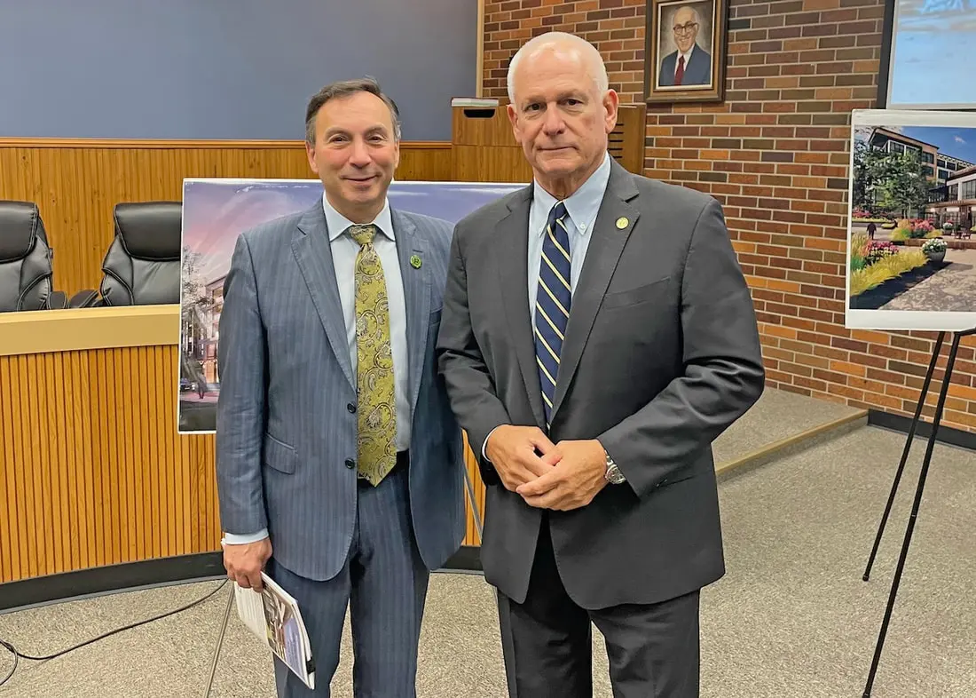 Two men in suits standing next to each other.