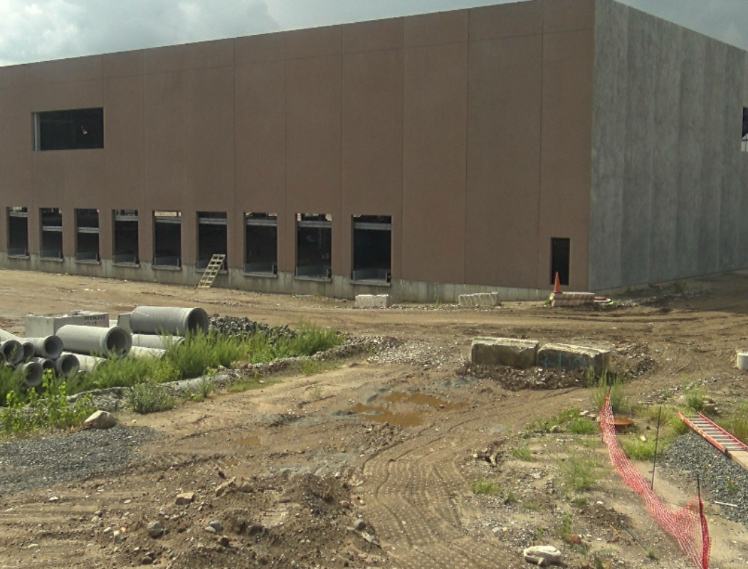 A building that is being built in the dirt.